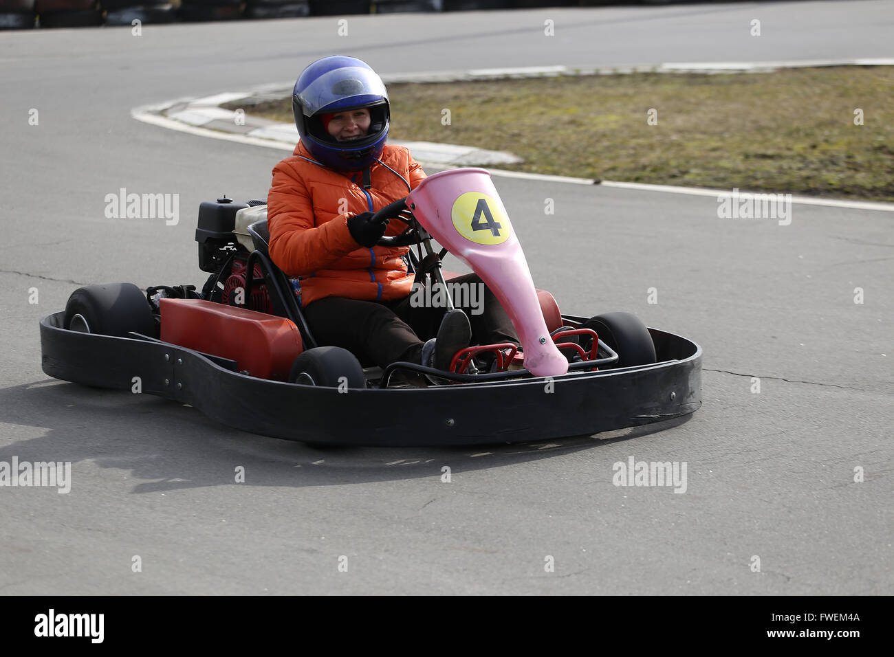 girl is driving Go-kart car with speed in a playground racing track. Go kart is a popular leisure motor sports. Stock Photo