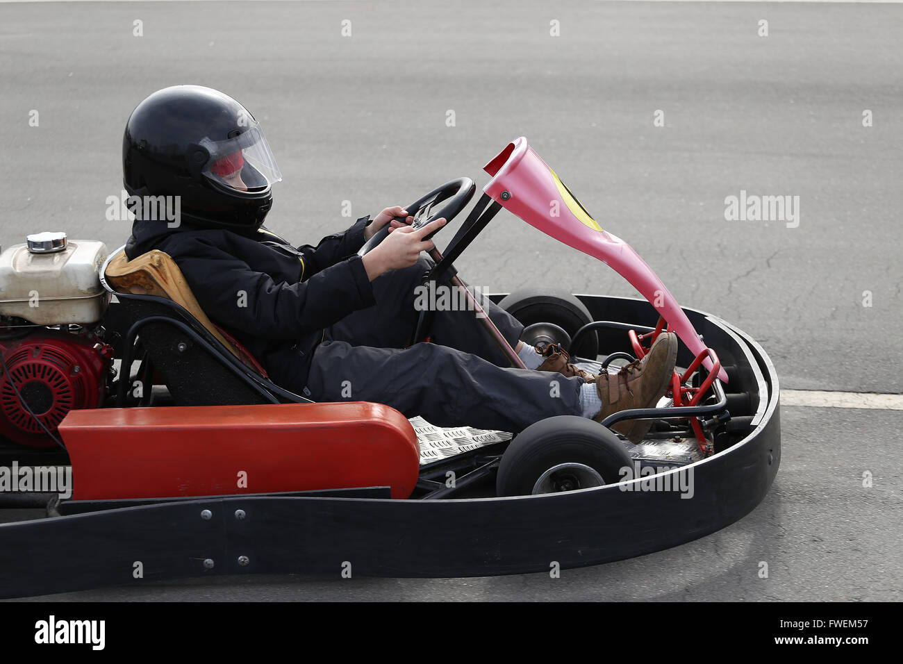 boy is driving Gokart car with speed in a playground racing track. Go