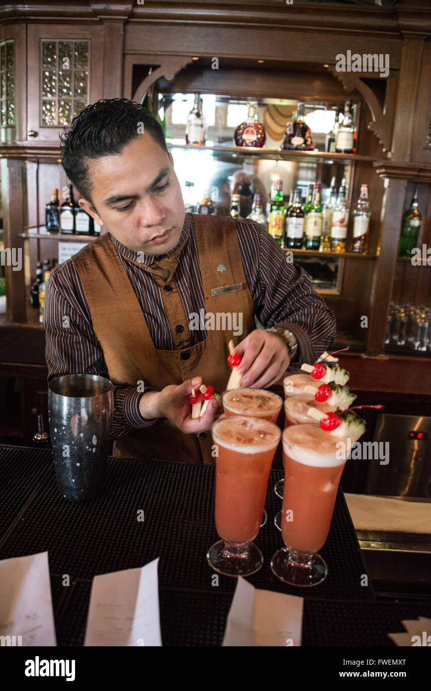 A barman making the famous cocktail drink,' Singapore Sling' in the Long Bar at the Raffles Hotel in Singapore. Stock Photo