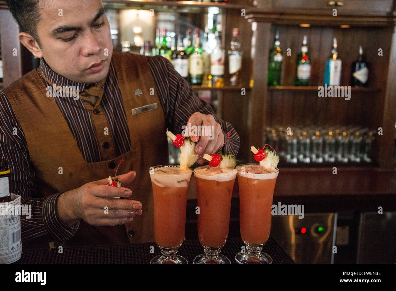 A barman making the famous cocktail drink,' Singapore Sling' in the Long Bar at the Raffles Hotel in Singapore. Stock Photo