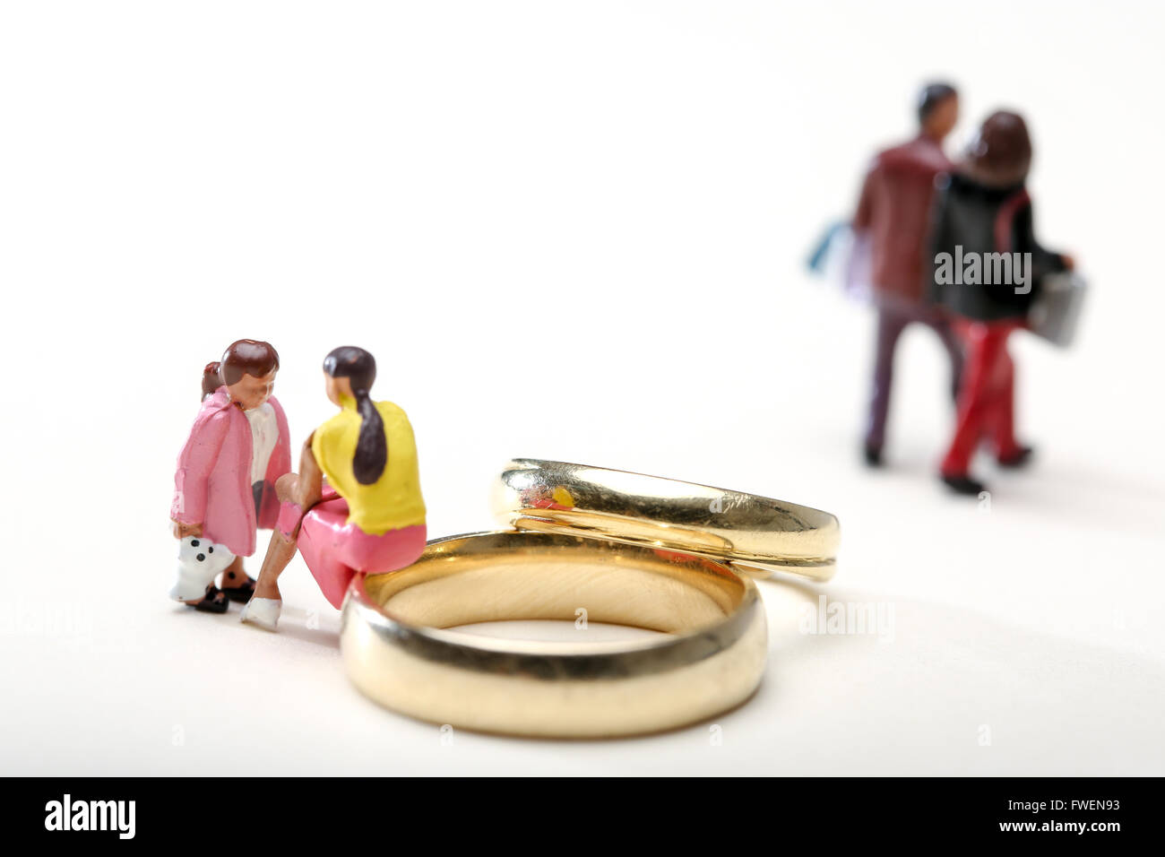 Concept image of a woman sat on wedding rings talking to a child to illustrate divorce the effects on children Stock Photo
