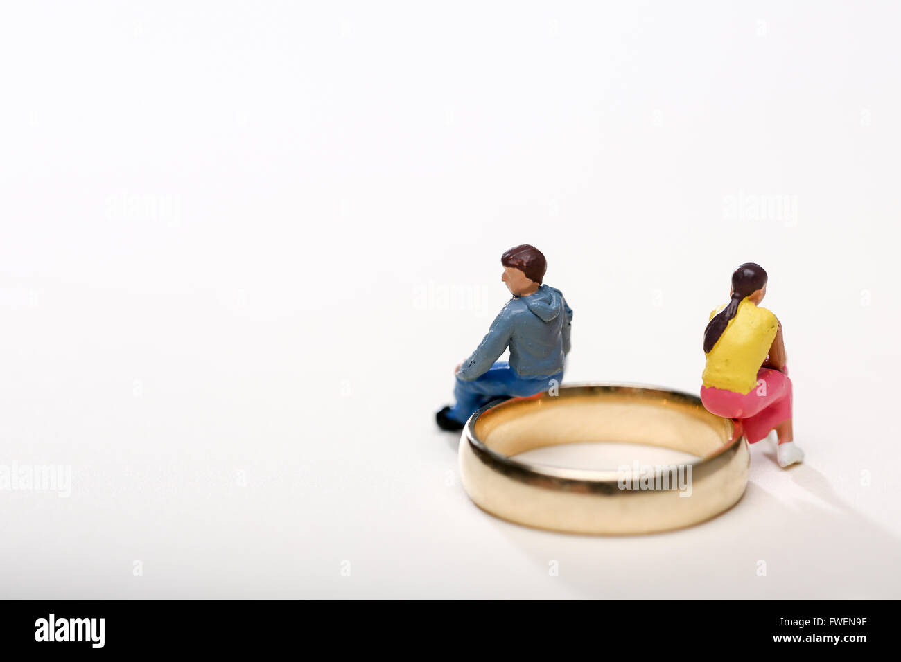 Concept image of a couple sat on wedding rings to illustrate divorce and separation Stock Photo