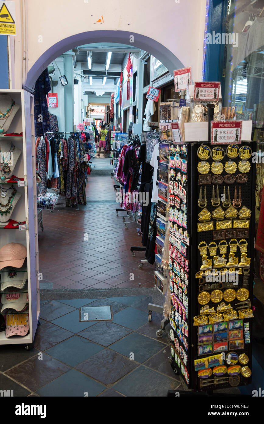 A narrow archway with rows of small shops lined with a variety of