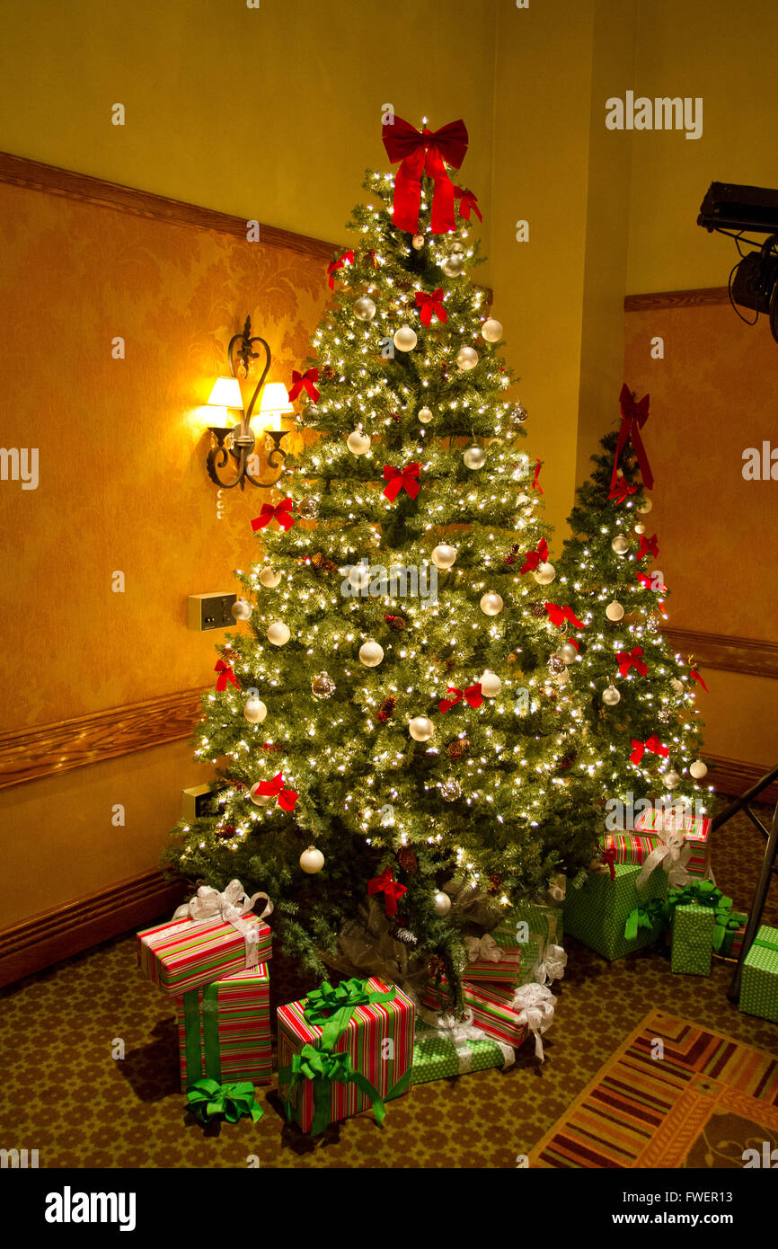 A beautiful Christmas tree with lights, ornaments, and presents under