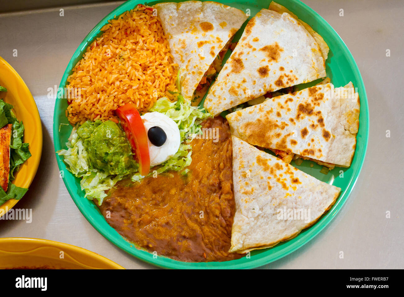 An authentic quesadilla at Mexican restaurant with rice and beans. Stock Photo
