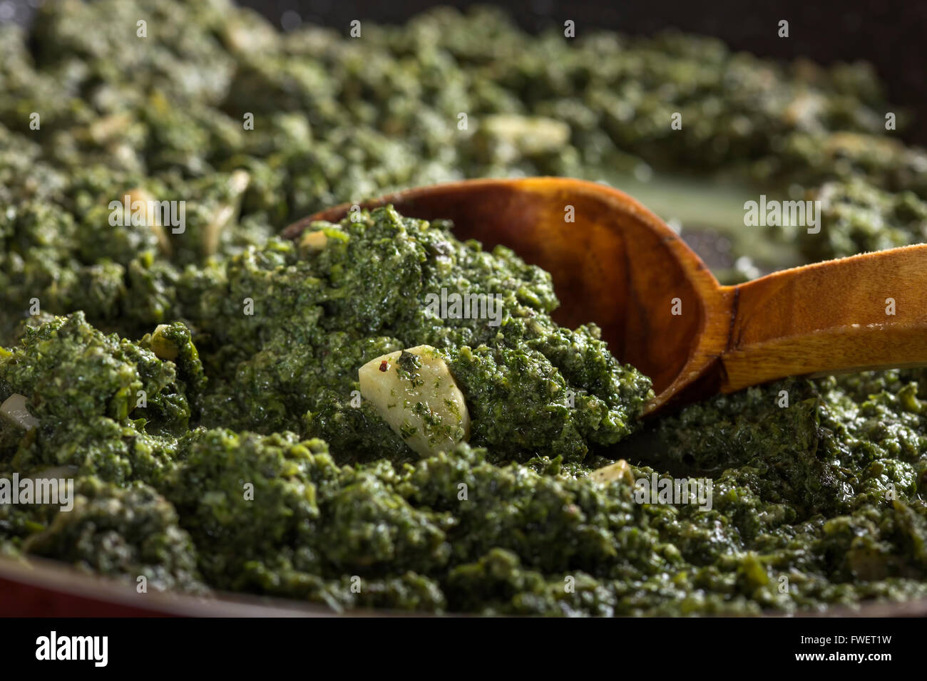 Stewed nettles with cream sauce and garlic in cooking pot with spoon Stock Photo
