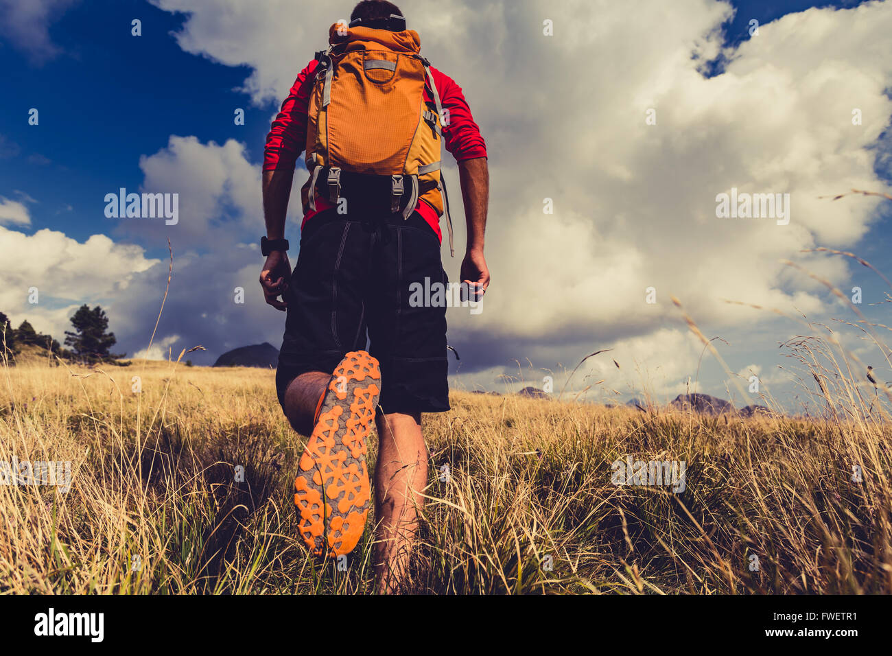 Hiking man or trail runner walking in mountains. Travel in Italy, Europe. Fitness and healthy lifestyle outdoors in fall autumn Stock Photo