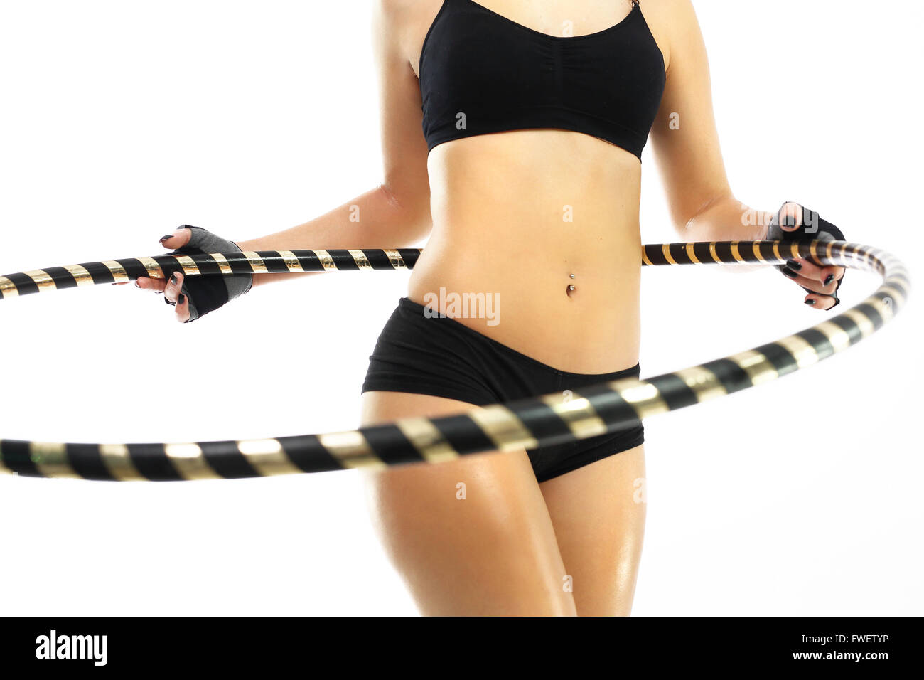 The woman is training your abdominal muscles by turning the wheel hula hoops. Circle hula hoops, a way to a flat stomach. Stock Photo