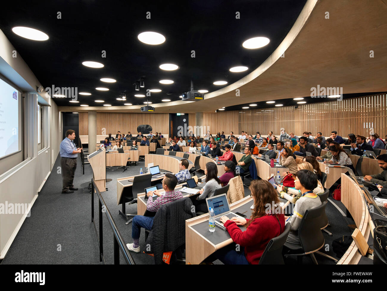 Curved lecture hall with students. The Blavatnik School of Government at the University of Oxford, Oxford, United Kingdom. Archi Stock Photo