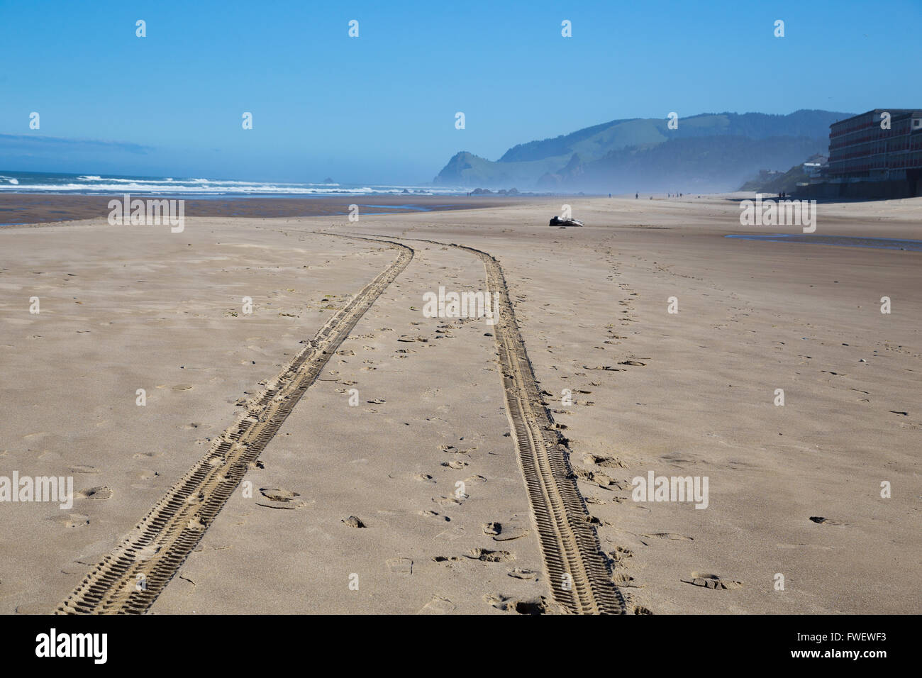 A set of tire mark tracks goes down the beach after a safety vehicle