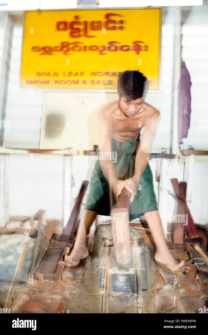 A gold beater beating pure gold into gold leaf, Mandalay, Myanmar, Southeast Asia Stock Photo