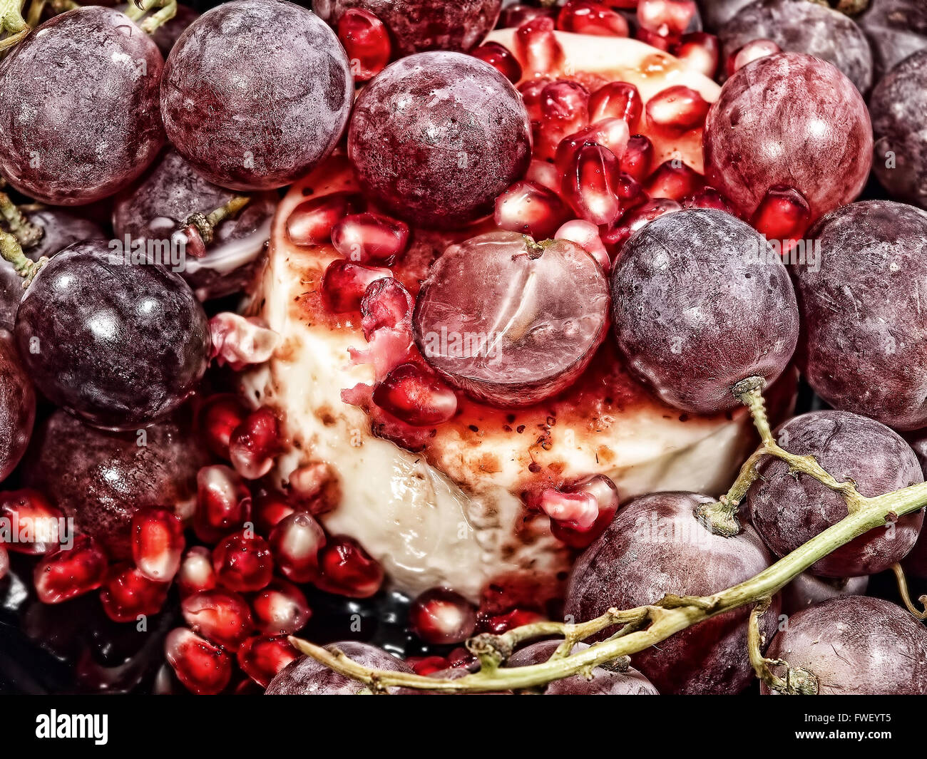 Sweet dessert with fresh pomegranate grains and grapes berries. Stock Photo