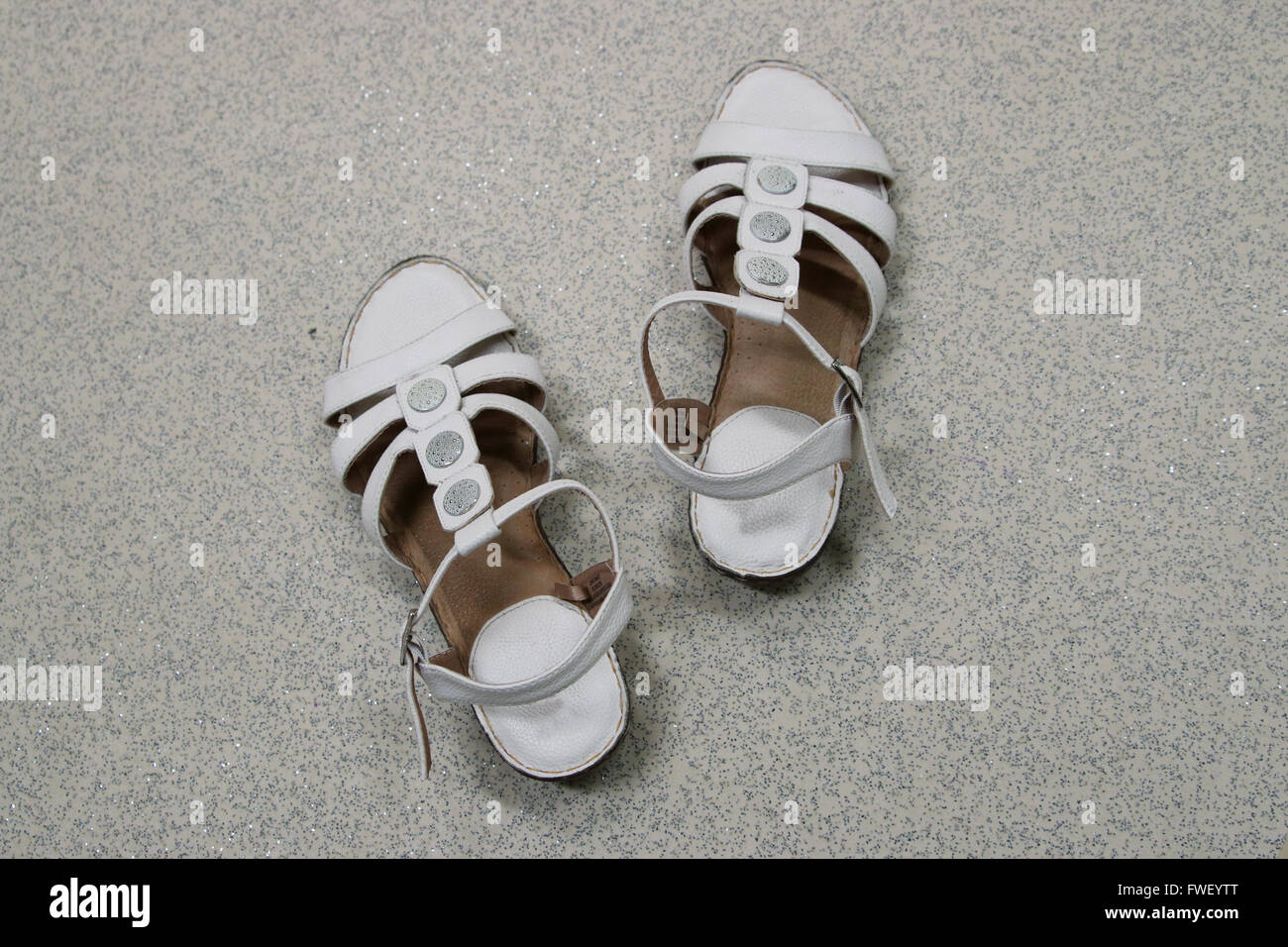 A Pair of white sandals on the floor Stock Photo
