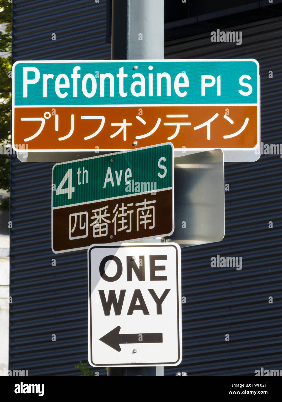 English and Chinese bilingual street signs at intersection Prefontaine Place South and 4th Avenue South. Seattle, WA, USA. Stock Photo