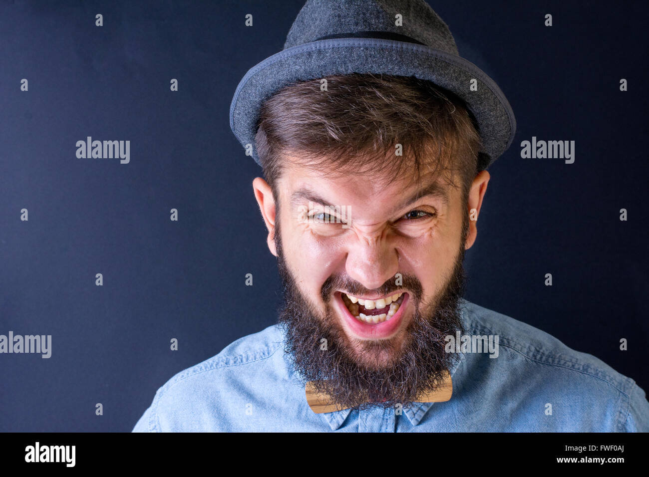 Angry bearded man yealing in a blue shirt Stock Photo