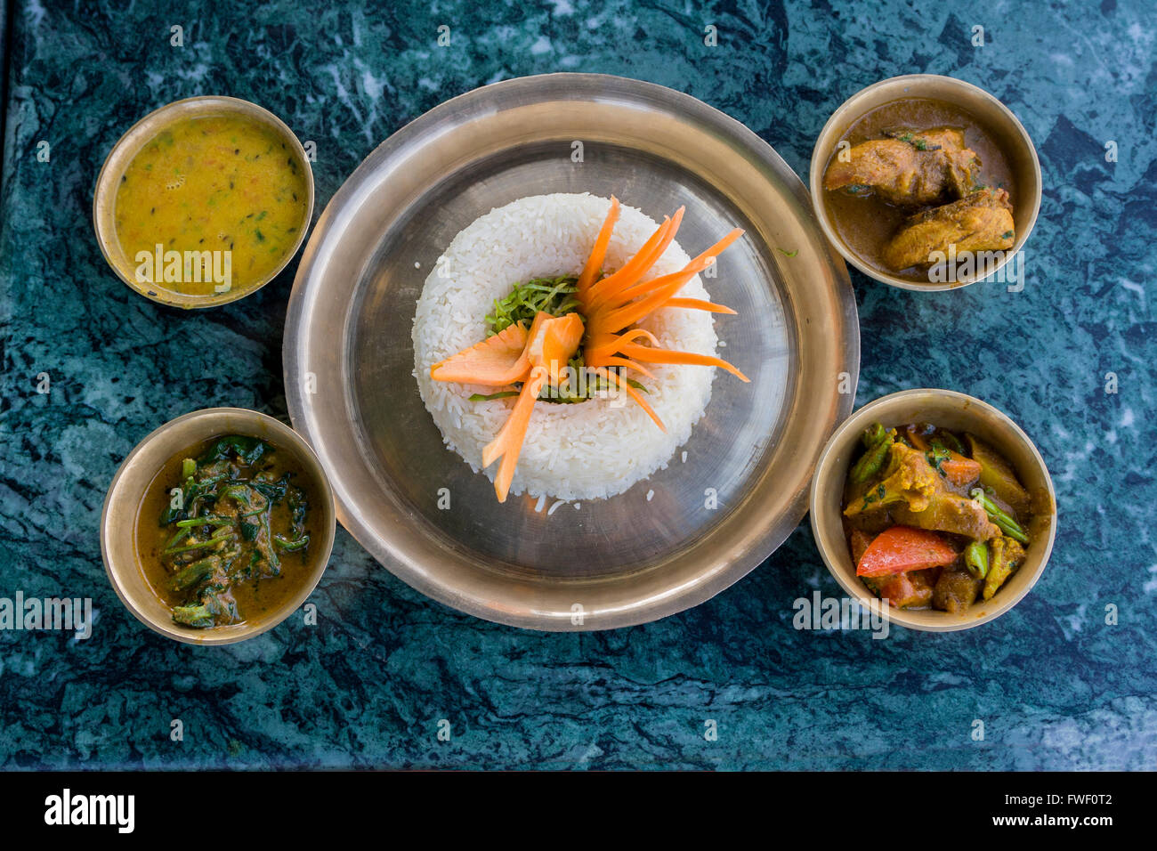 Nepal, Kathmandu, Swayambhunath.  A Nepalese Lunch:  rice, curried vegetables, chicken, spinach, lentil sauce. Stock Photo