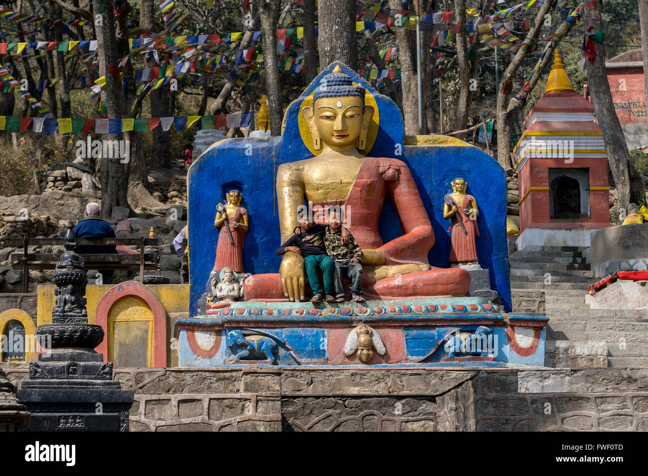 Nepal, Kathmandu, Swayambhunath. Young Boys Sitting in Lap of Buddha