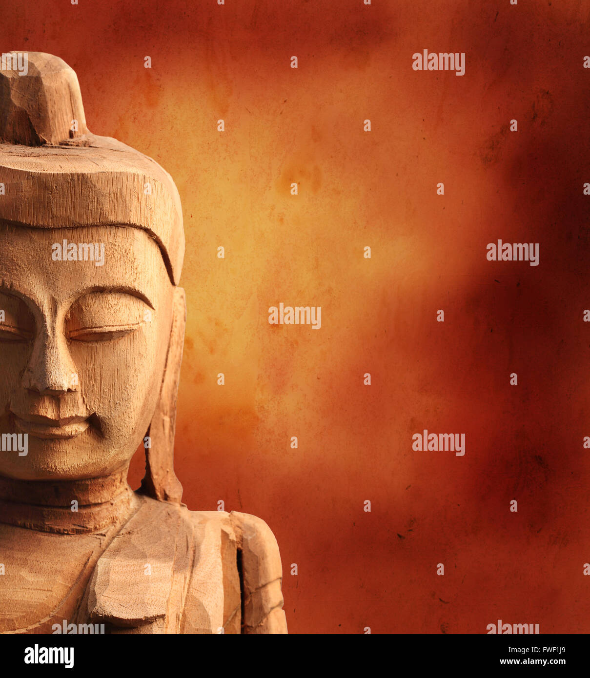 Half of wood Buddha Face on Grunge Background Stock Photo