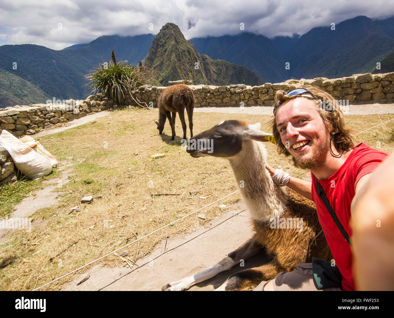 self-portrait of smiling young man in red t-short near old town of machu-picchu, peru Stock Photo