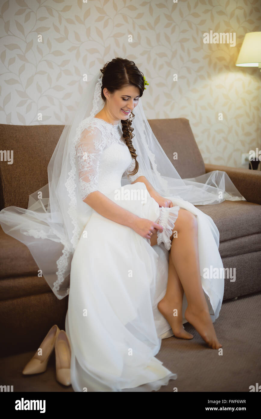 Premium Photo  White girdle put on a leg of a bride shortly before the  wedding