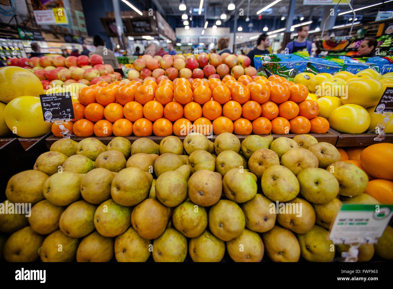 a tightly packed stack of fruit on display in the produce section of a