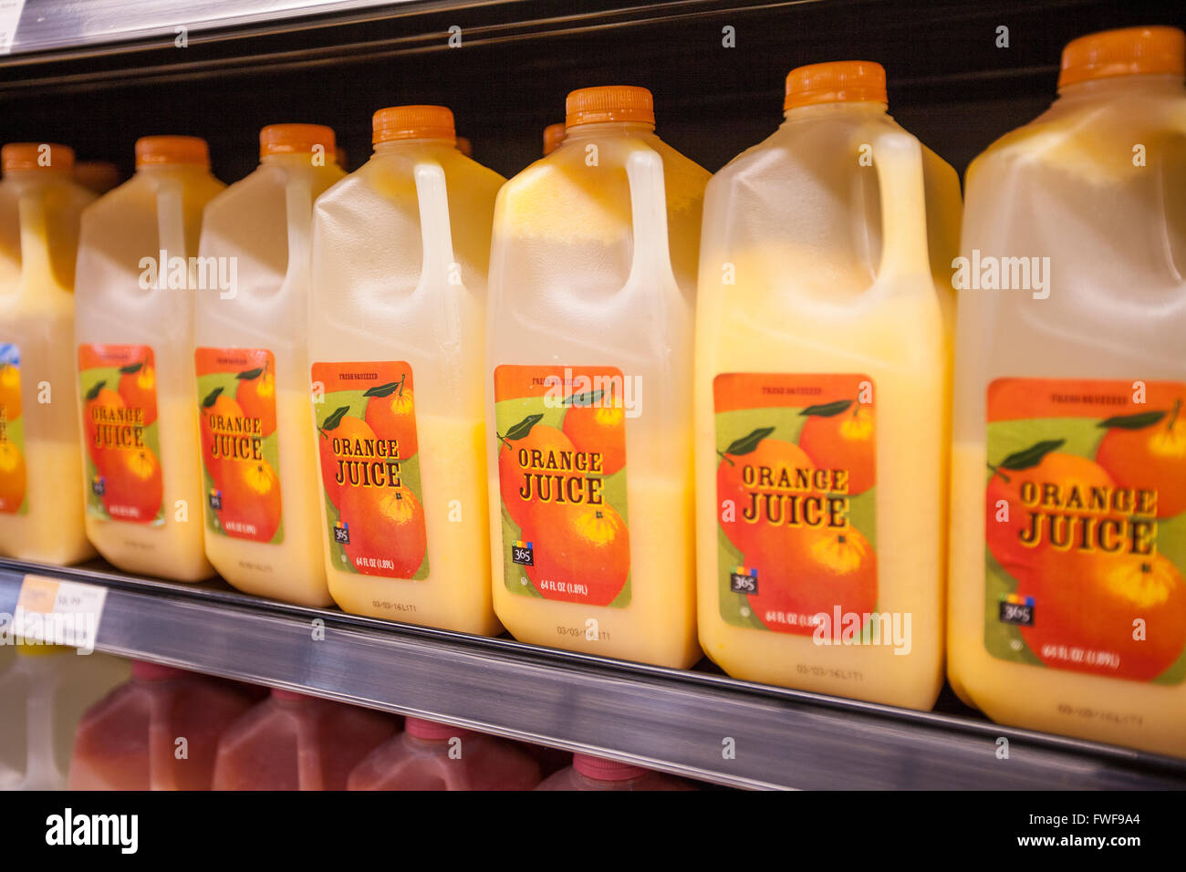 A shelf of 365 Brand orange juice cartons in a refrigerator case at a Whole Foods grocery store. Stock Photo