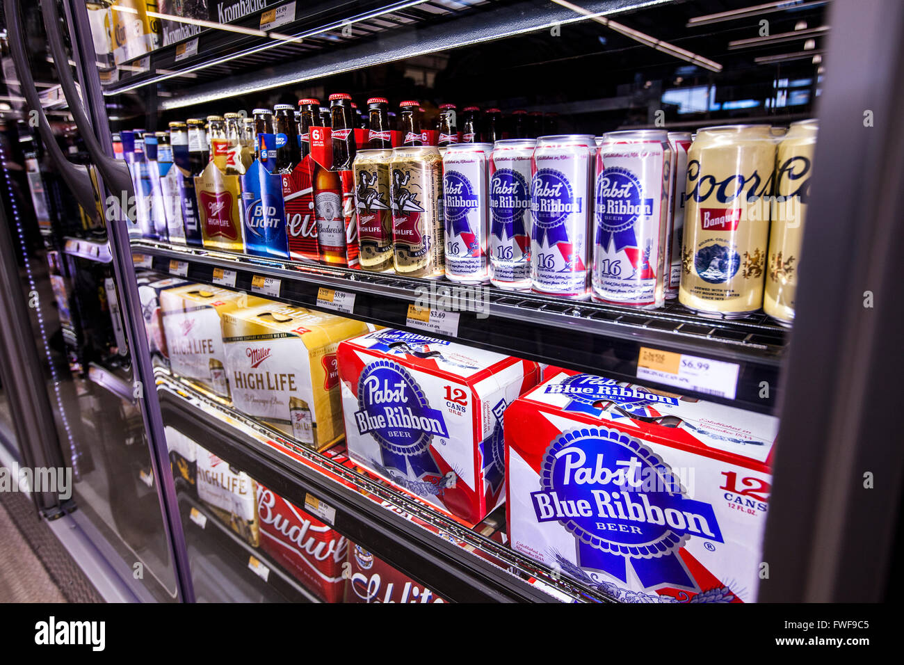 Shelves of six pack American made domestic beer in the refrigerator case of a store. Stock Photo