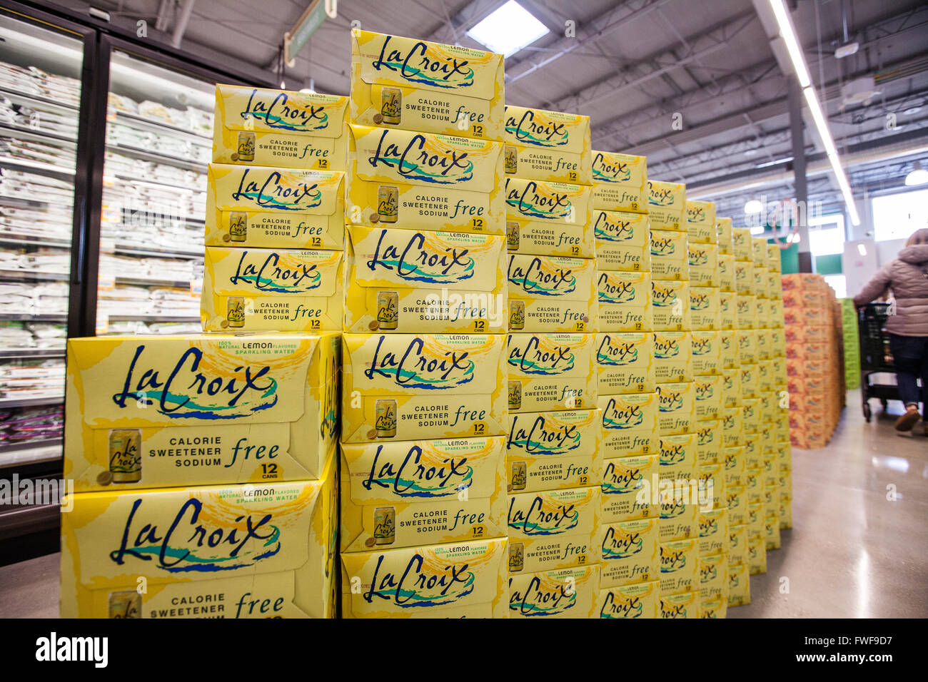 Cases of La Croix sparkling water stacked as a display in the aisle