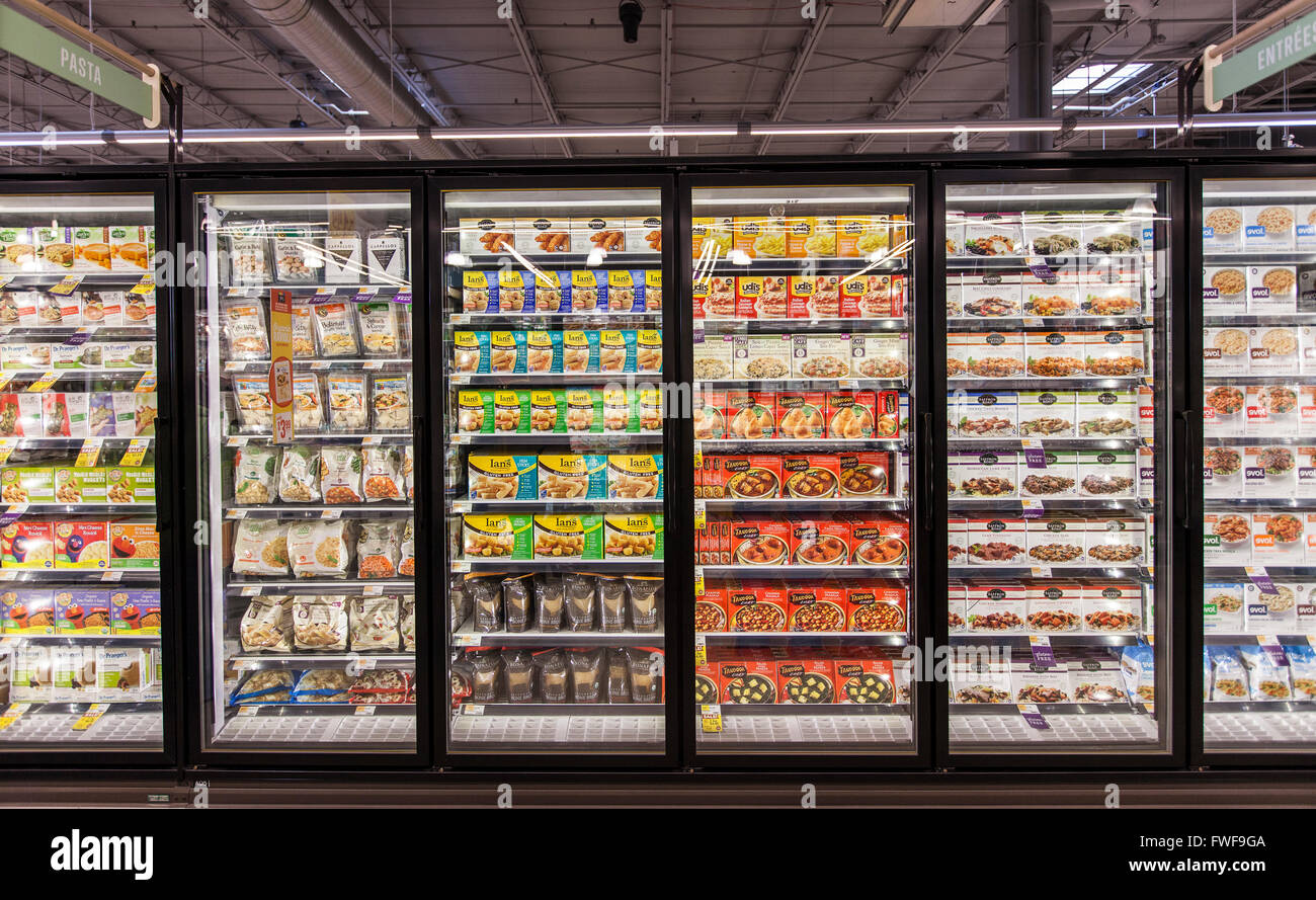 Glass freezer cases of organic and natural frozen foods at a grocery store. Stock Photo