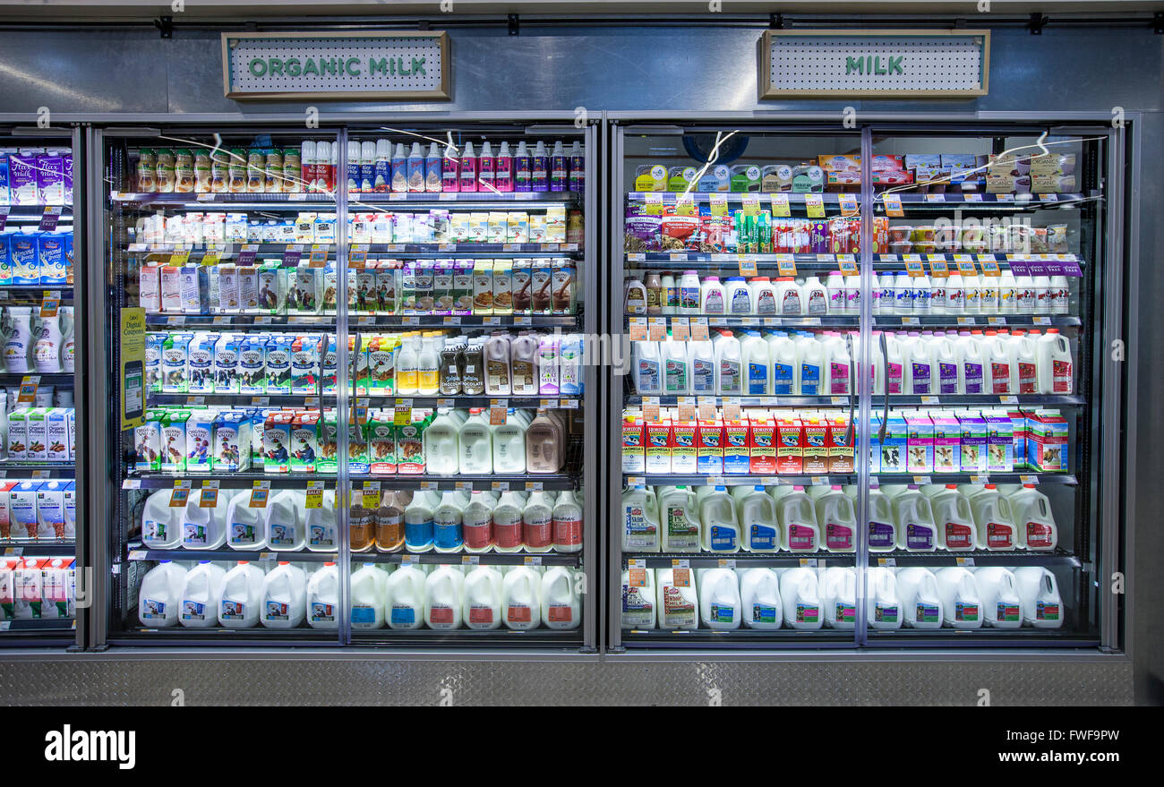 Organic and regular milk displayed in a dairy case at a grocery store Stock Photo