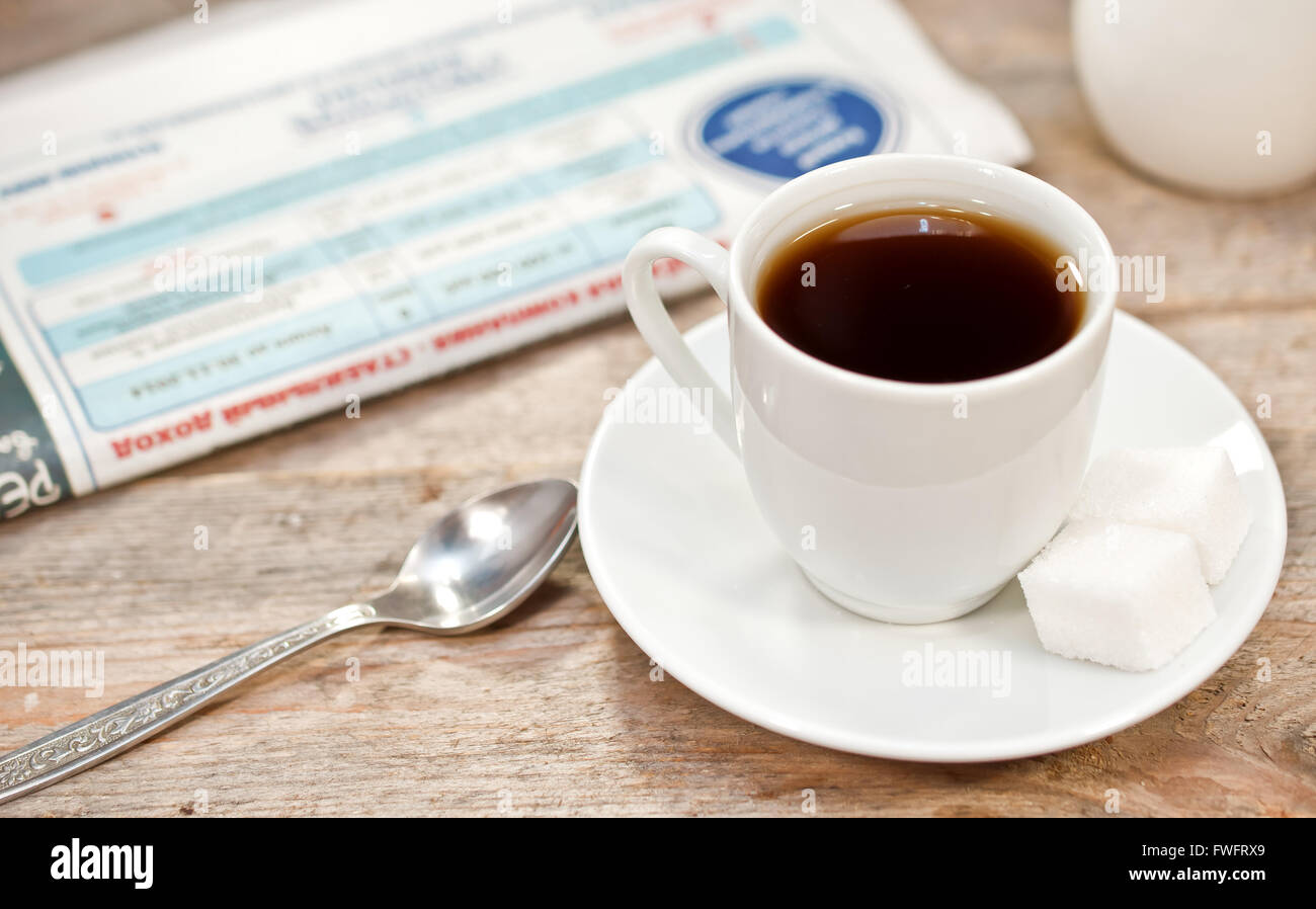 Cup of coffee and newspaper on a wooden table Stock Photo