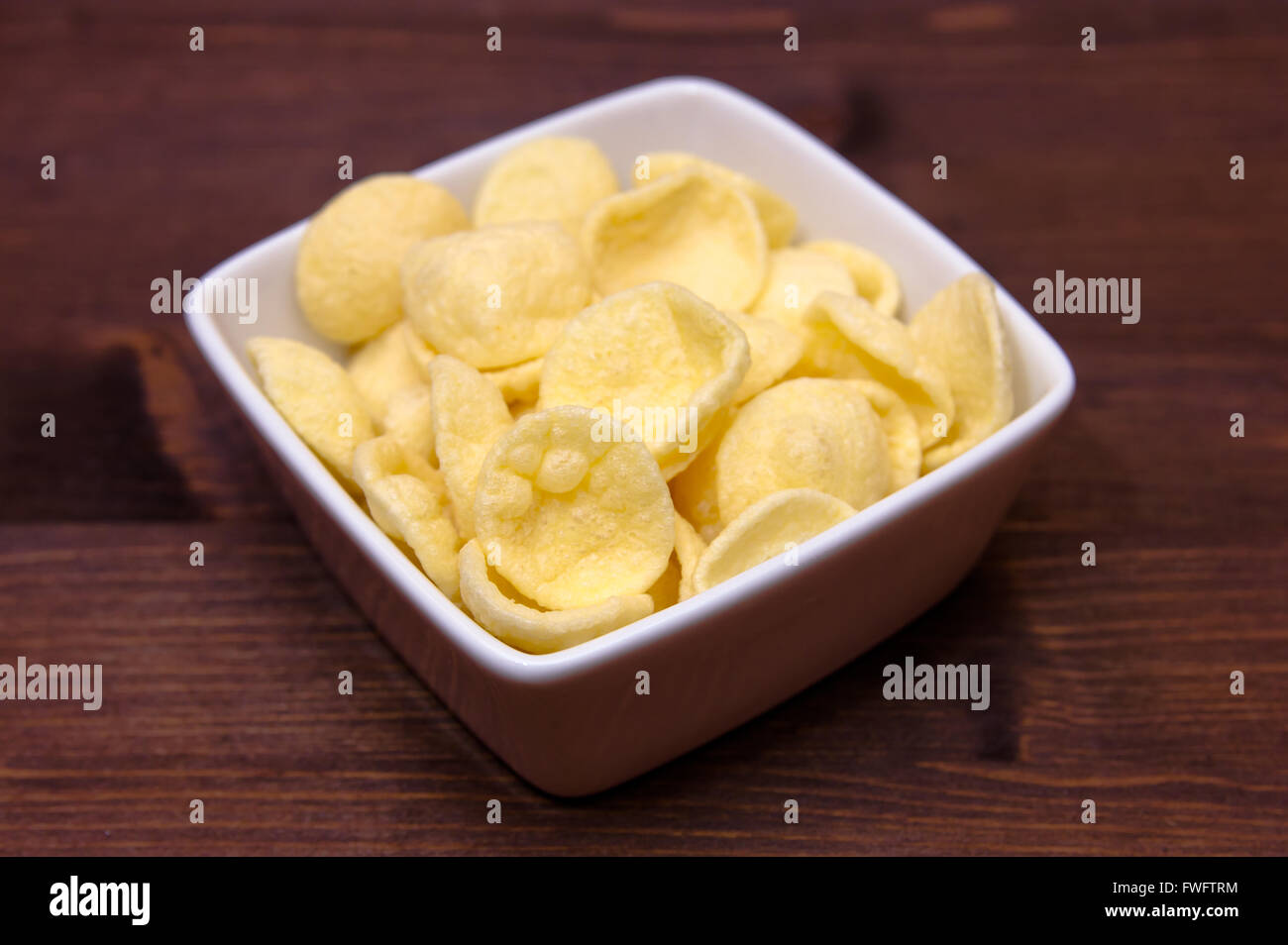 Potato snacks on a square bowl on wooden table Stock Photo