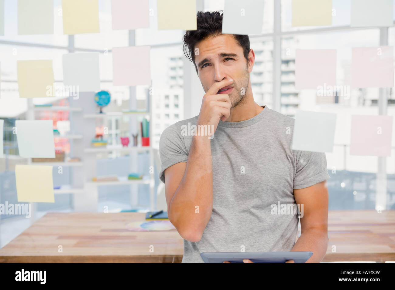 Thoughtful man looking at sticky notes on window Stock Photo - Alamy