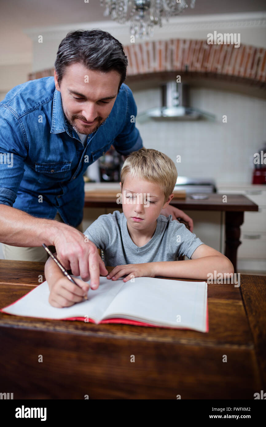 Father helping son with his homework in kitchen Stock Photo - Alamy