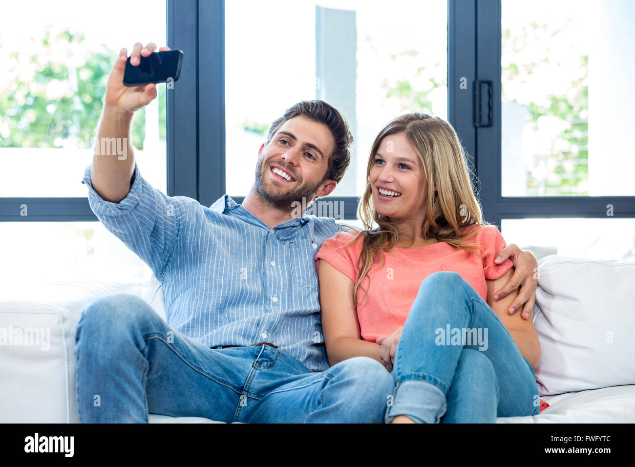 Cheerful young couple taking selfie Stock Photo - Alamy