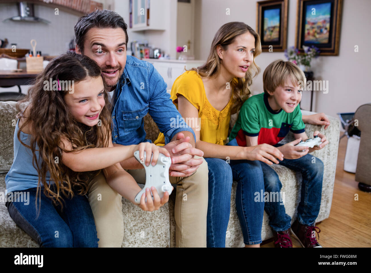 Family sitting on sofa and playing video game Stock Photo