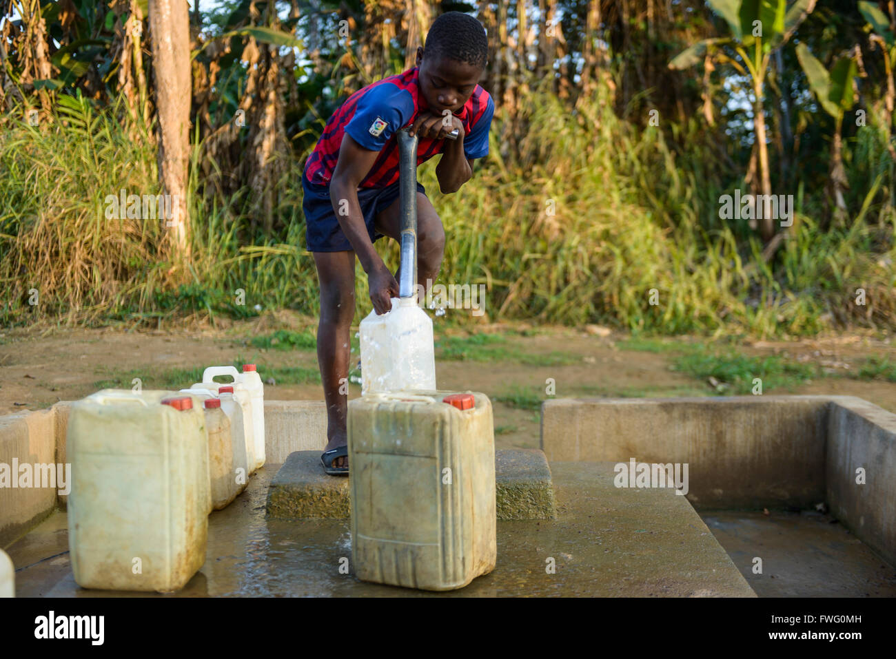 Boy collecting water, Gabon, Central Africa Stock Photo