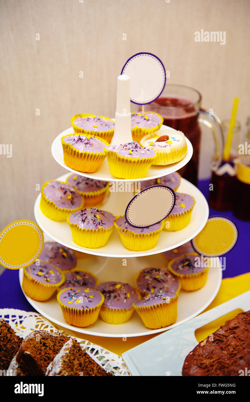 many sweet birthday cupcakes with flowers and butter cream purple, yellow style Stock Photo