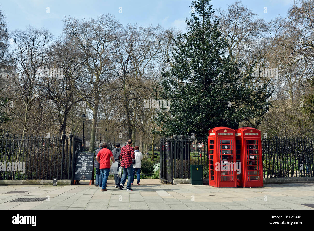 People entering Russell Square with red telephone boxes to side, London Borough of Camden England Britain UK Stock Photo