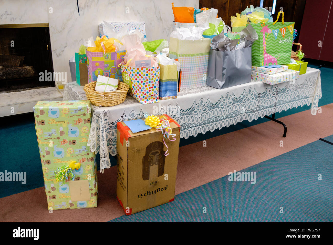 A baby shower gift table with colorful packages and a lace tablecloth. USA. Stock Photo