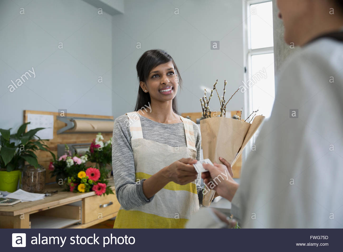 Woman paying florist with credit card flower shop Stock Photo