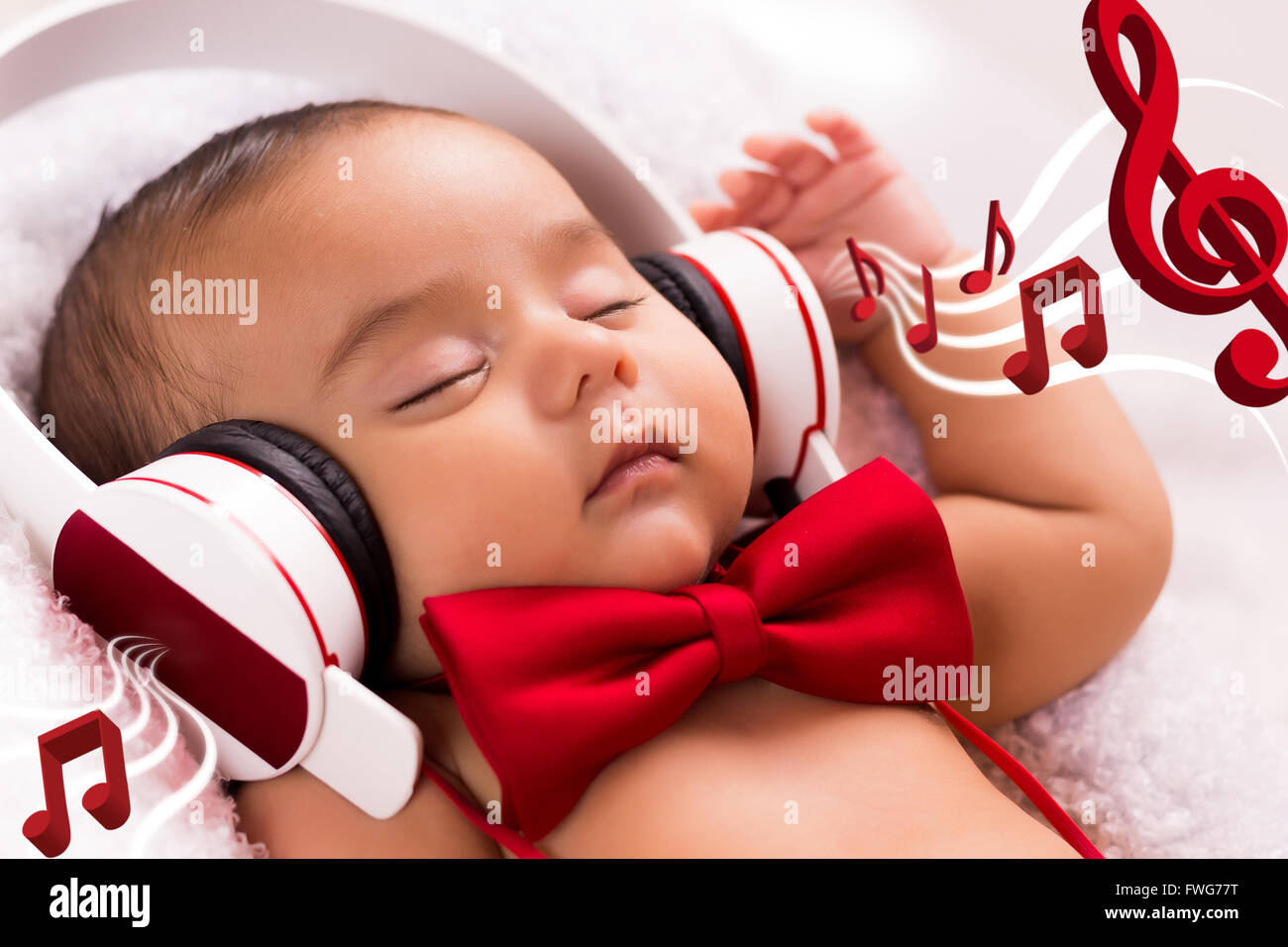 beautiful baby two months old relaxed listening music with headphones, using a vintage red tie Stock Photo