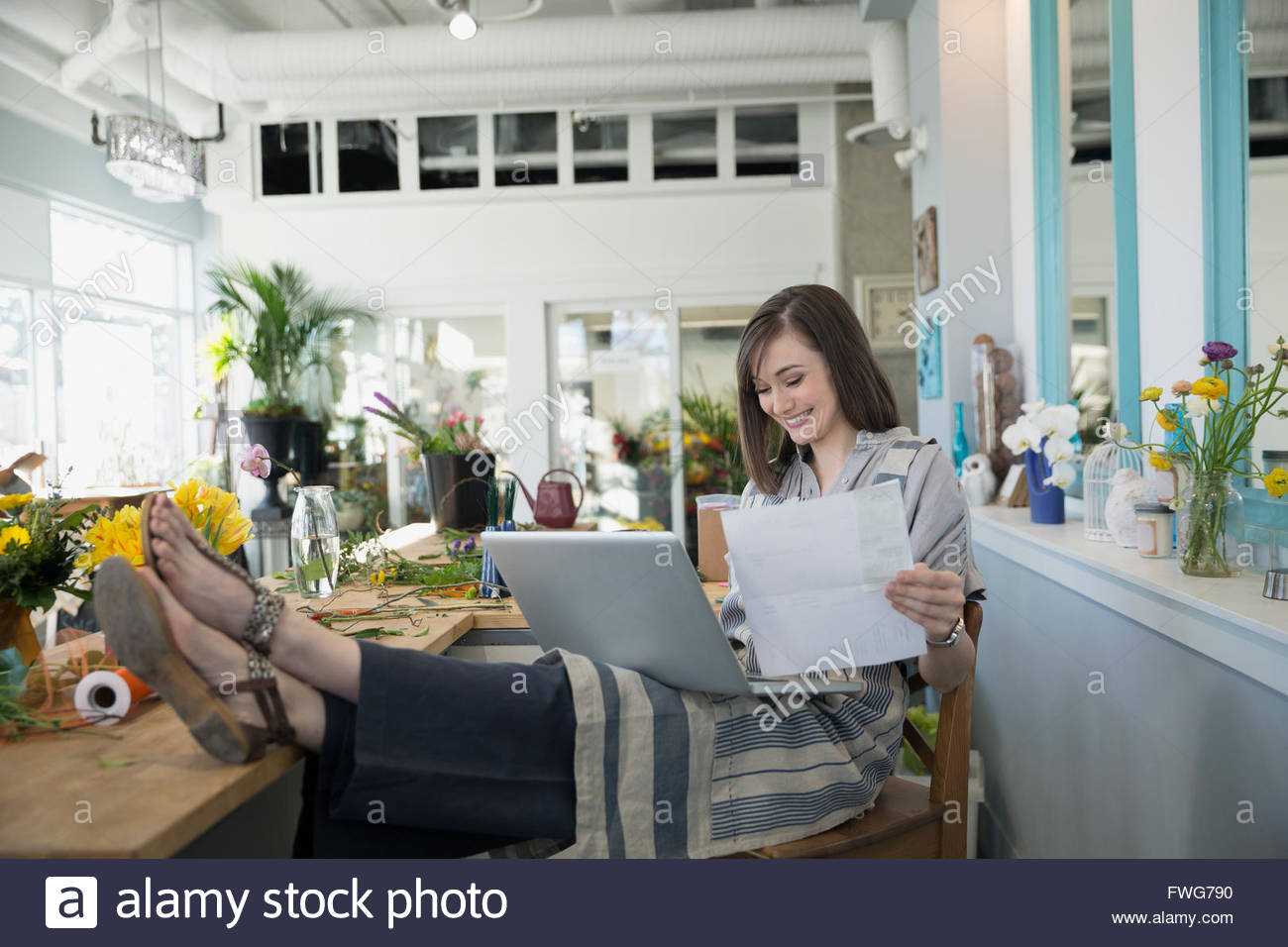 Florist using a laptop with feet up Stock Photo