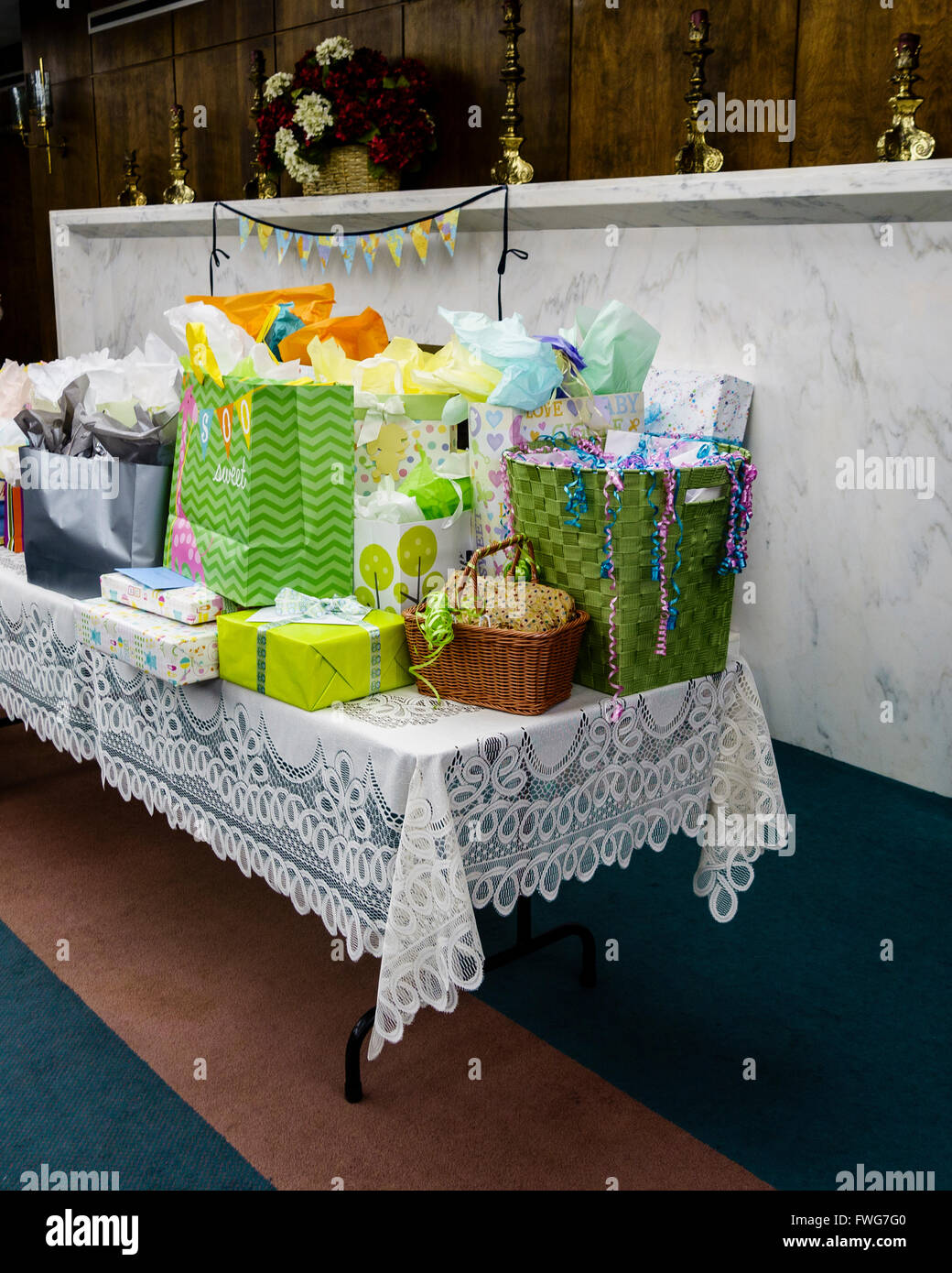 A baby shower gift table with colorful packages and a lace tablecloth. USA. Stock Photo