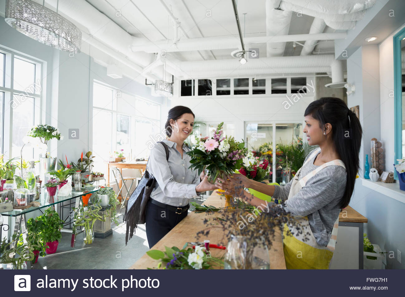 Florist presenting bouquet to customer in flower shop Stock Photo