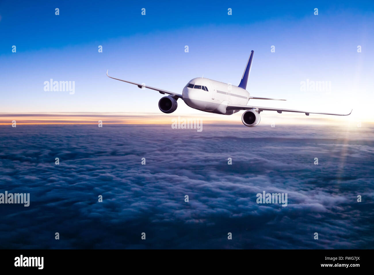 Commercial airplane flying above clouds in dramatic sunset light Stock ...