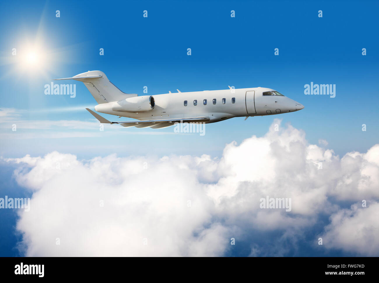 Luxury private jet plane flying above clouds in day light Stock Photo