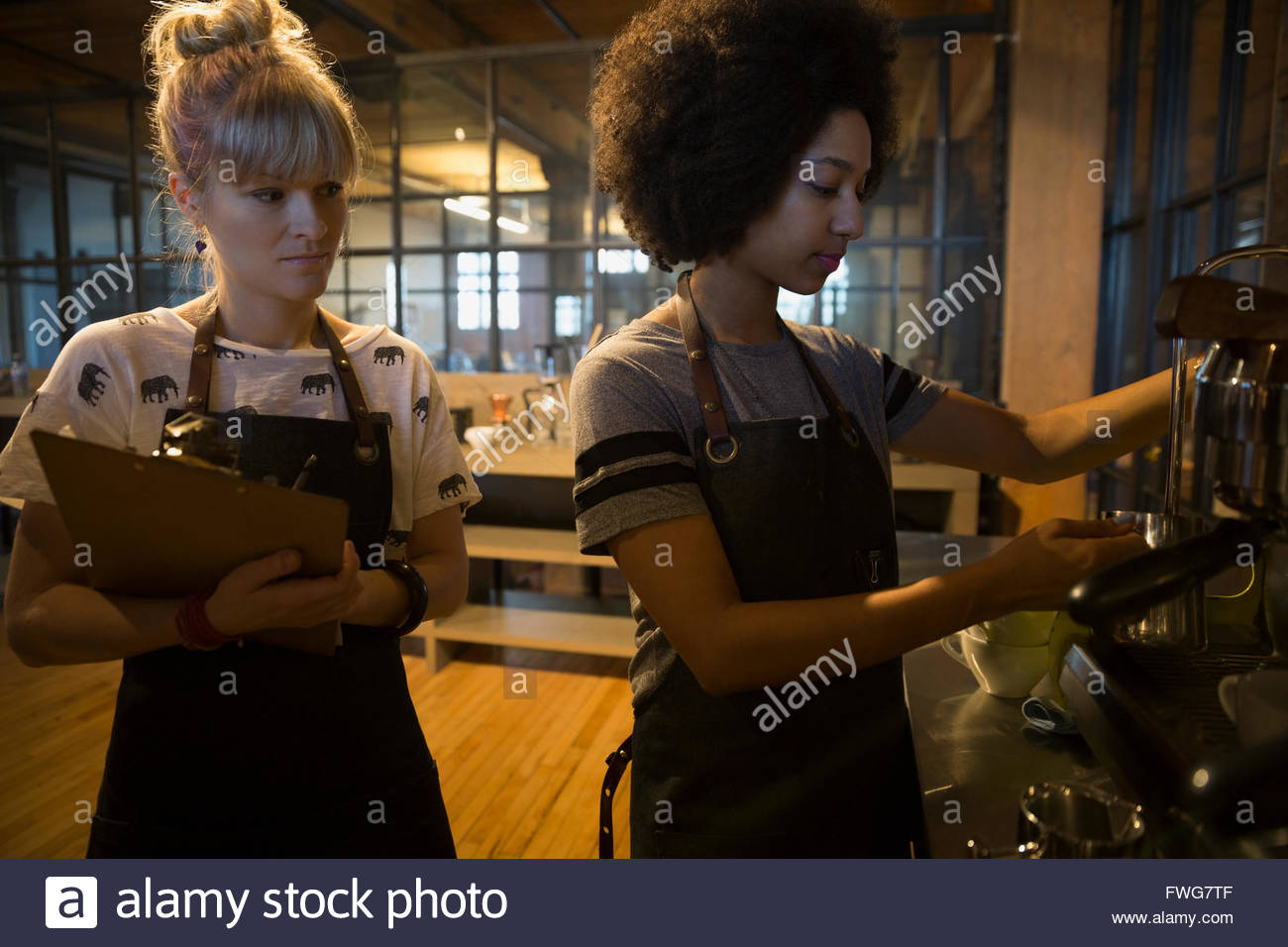 Baristas with clipboard using espresso machine in coffee shop Stock Photo Alamy