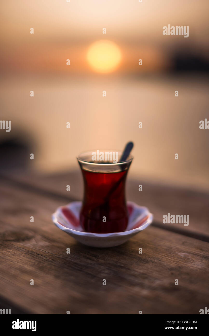 Turkish tea on a wooden table and sunset. Stock Photo