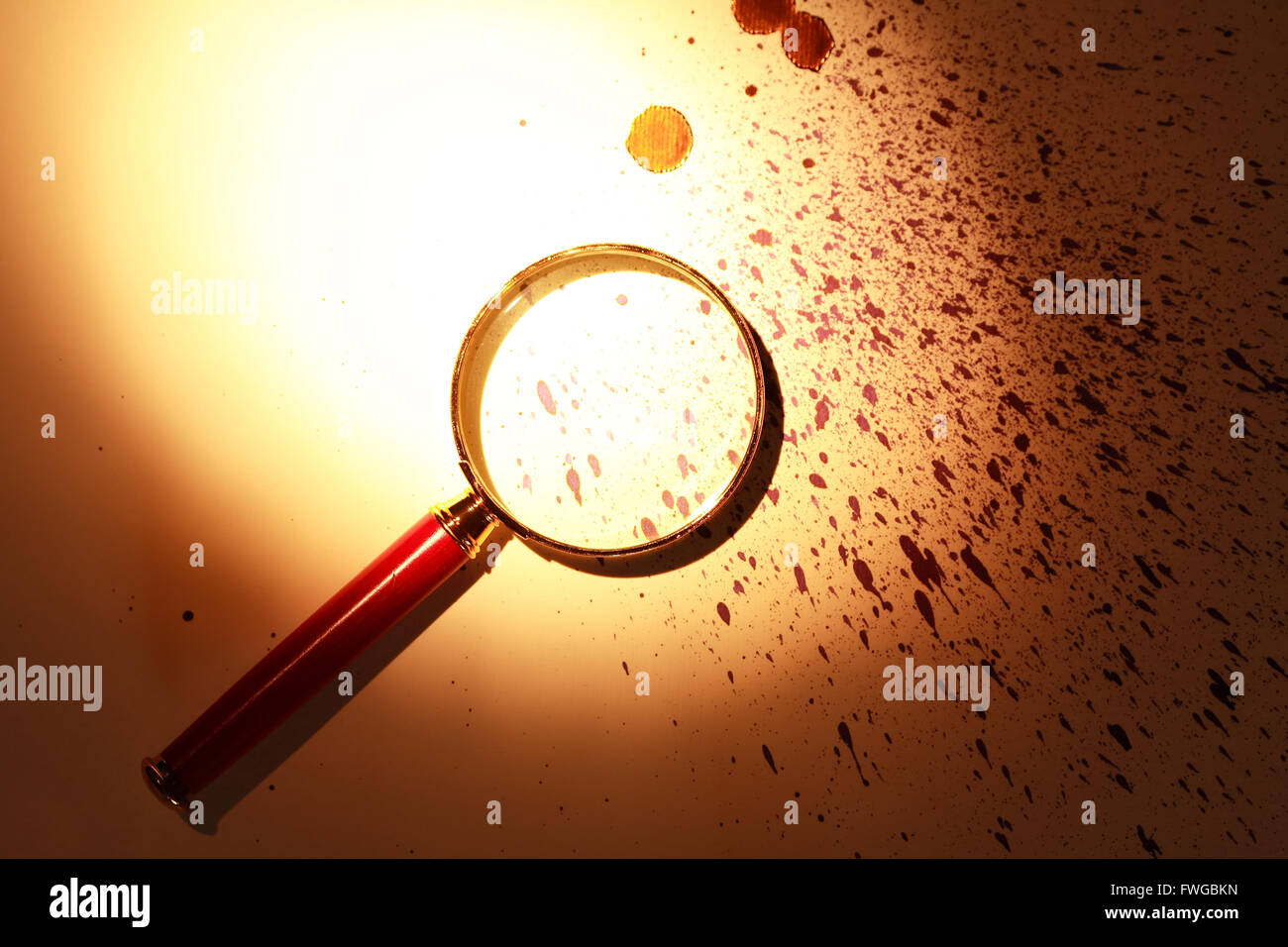 Investigation symbol. Magnifying glass on paper background with drops Stock Photo